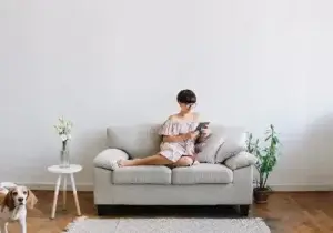 Mulher sentada lendo um livro num sofá